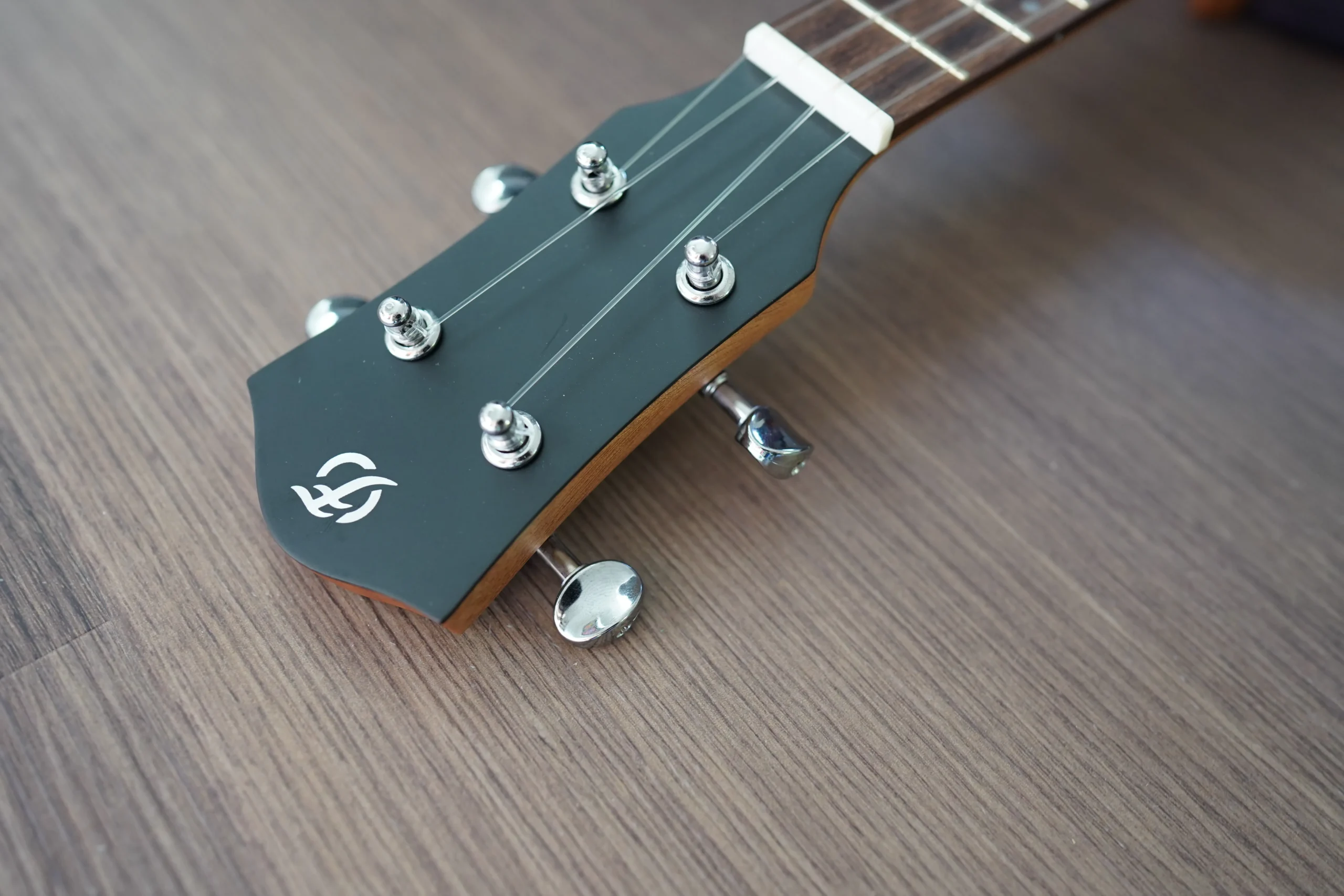 Front view of the Flight DUC 400 Ash Purple ukulele headstock with chrome tuning machines and matte black finish.